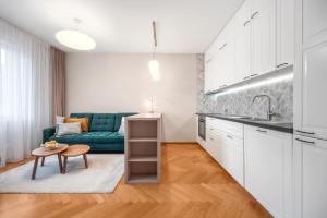 a kitchen and living room with a green couch at Modern old town apartment in Bratislava