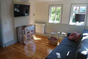 a living room with a blue couch and a tv at Tauber Lodge in Creglingen