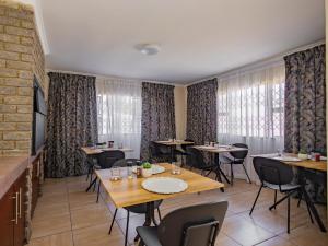 a dining room with tables and chairs and windows at Olive Grove Bed & Breakfast in Kraaifontein +13 photos