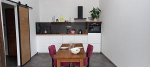 a kitchen with a wooden table and purple chairs at La Bulle Enchantée in Berru