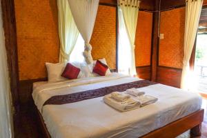 a bedroom with a large bed with towels on it at Le mont pai resort in Pai