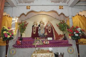a altar with two statues in a room with flowers at Omji Ashram Jageshwar Mahadev in Varanasi