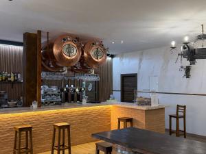 a restaurant with a bar with chairs and clocks on the wall at Hostal Gran Capitán in Toledo
