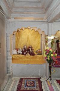 a room with a bed with a yellow curtain at Omji Ashram Jageshwar Mahadev in Varanasi