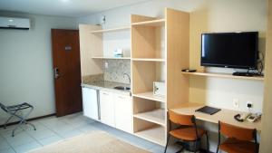 Habitación con cocina con escritorio y TV. en Littoral Express en João Pessoa