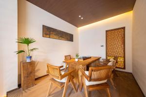 a dining room with a wooden table and chairs at Shiershan · Yuntang Hotel in Qingdao
