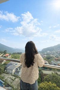 a woman standing on top of a tower looking at a city at Daisy Hotel Tam Dao in Tam Ðảo +52 photos