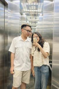 a man and a woman taking a picture in an elevator at Daisy Hotel Tam Dao in Tam Ðảo