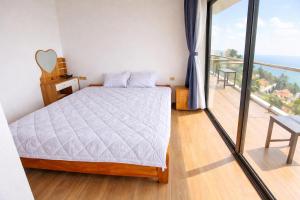 a bedroom with a bed and a balcony at Daisy Hotel Tam Dao in Tam Ðảo