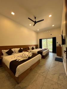 a bedroom with two beds and a ceiling fan at Mount court munnar in Munnar