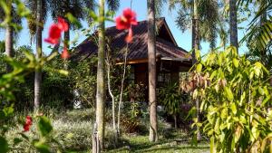 a house in the jungle with palm trees at Le mont pai resort in Pai
