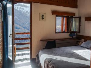 a bedroom with a bed and a large window at Le Grand Tetras in Saint-Véran