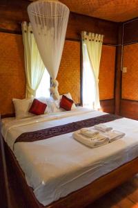 a bedroom with a large white bed with a window at Le mont pai resort in Pai +16 photos