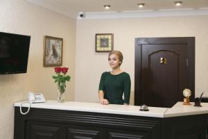 a woman standing in front of a reception desk at Hotel Yunost in Yekaterinburg