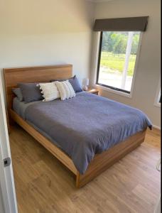 a large bed in a bedroom with a window at BrinCole - Pet-Friendly, Huge Deck with Epic Views & Fire Pit in Bonnie Doon