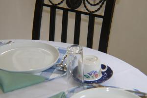 a table with a plate and a bowl and a candle at Joyful Vista Guest Lodge in Victoria Falls +9 photos