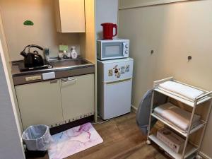 a small kitchen with a sink and a microwave at Peace Wing 3C in Hiroshima