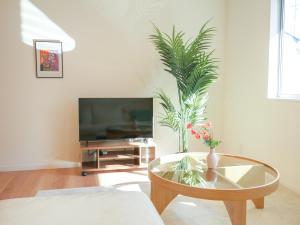 a living room with a glass table and a tv at 9Stay伊勢崎 in Isesaki