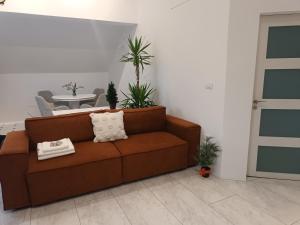 a brown couch in a living room with a table at Popas 26 in Nădlac