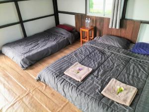 a bedroom with two beds with towels on them at Ricefield Homestay มองนาภูคาน่านโฮมสเตย์ in Ban Thon (1) +27 photos