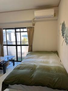 a bedroom with a bed with a air conditioner on the wall at Peace Wing 5A in Kami-nagarekawachō