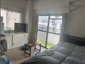 a bedroom with a bed and a view of a balcony at Peace Wing 5A in Kami-nagarekawachō