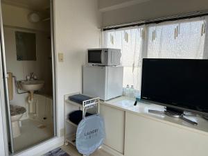 a room with a television and a sink and a window at Peace Wing 5A in Kami-nagarekawachō +20 photos