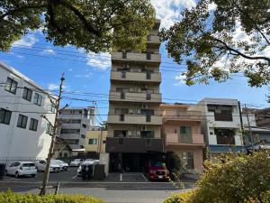 a tall building with cars parked in front of it at Peace Wing 5A in Kami-nagarekawachō