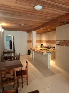 a large kitchen with wooden ceilings and a table and chairs at Pousada Paraíso dos Corais in Arraial do Cabo