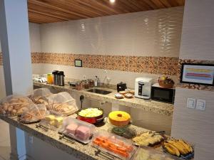 a kitchen with a counter with food on it at Pousada Paraíso dos Corais in Arraial do Cabo +40 photos