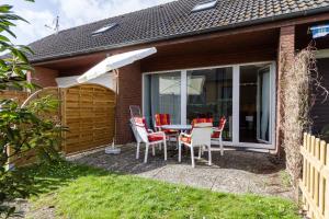 a patio with a table and chairs and an umbrella at Ferienwohnung "Mour" in Dahme