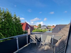 two chairs sitting on the balcony of a house at Ferienwohnung Leuchtfeuer in Burhave