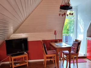 a dining room with a table and a tv at Ferienwohnung Leuchtfeuer in Burhave