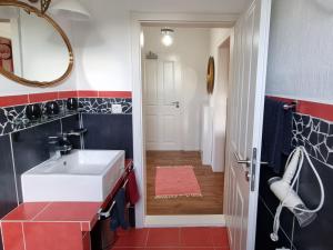 a bathroom with a white sink and red and blue tiles at Ferienwohnung Leuchtfeuer in Burhave +18 photos