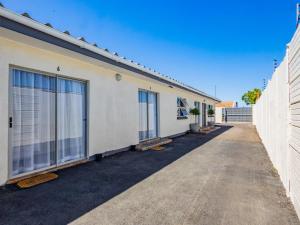 a white building with windows on the side of it at Olive Grove Bed & Breakfast in Kraaifontein