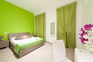 - une chambre verte avec un lit et une table dans l'établissement Bed & Breakfast Tramonti, à Trapani