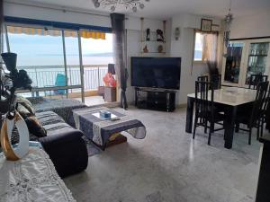 a living room with a couch and a television and a table at Appartement vue mer in Saint-Raphaël