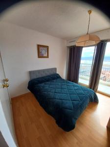 a bedroom with a bed and a large window at Appartement vue mer in Saint-Raphaël