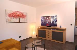 a living room with a television and a table and chairs at Ferienwohnung Petra in Ilmenau
