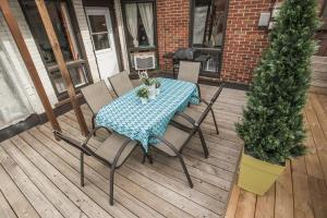 a table and chairs on a deck with a christmas tree at MtlVacationRentals - Appartements Plateau-Mont-Royal in Montréal