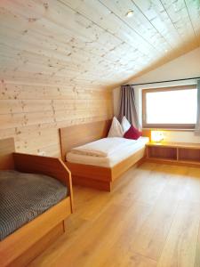 a room with two beds and a window at Ferienwohnungen Tauernalm in Heiligenblut