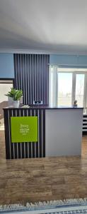 an office with a counter with a green sign on it at Koktem hostel in Aktobe +2 photos