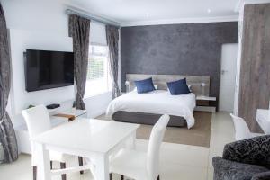 a bedroom with a bed and a table and a tv at Ti’amo in Wilderness