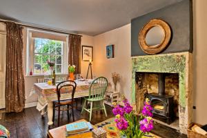 a living room with a table and a fireplace at Finest Retreats - Flittermouse Cottage in Wingfield