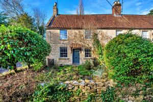 an old stone house with a stone wall at Finest Retreats - Flittermouse Cottage in Wingfield
