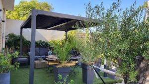 a black pergola with a table and some plants at Hôtel Boquier, Avignon Centre in Avignon