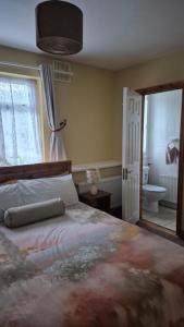 a bedroom with a large bed and a bathroom at Coolalingo B&B in Drumgoff Bridge
