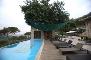 a swimming pool with lounge chairs and a green umbrella at The Silk Valley in Arşūn