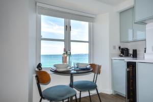 a kitchen with a table and chairs and a window with the ocean at 1 Bed in St Ives oc-crab02 in St Ives