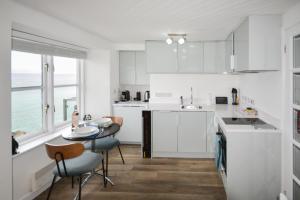 a kitchen with white cabinets and a table and chairs at 1 Bed in St Ives oc-crab02 in St Ives
